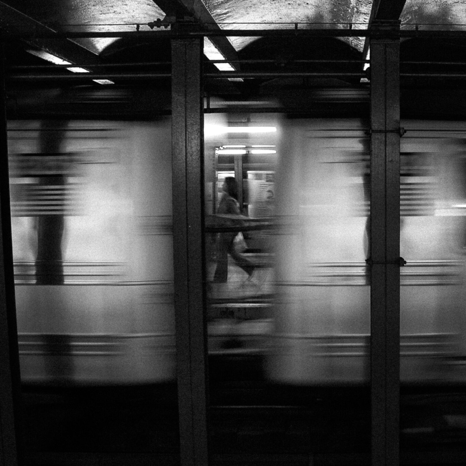 Person between moving subway cards, New York City