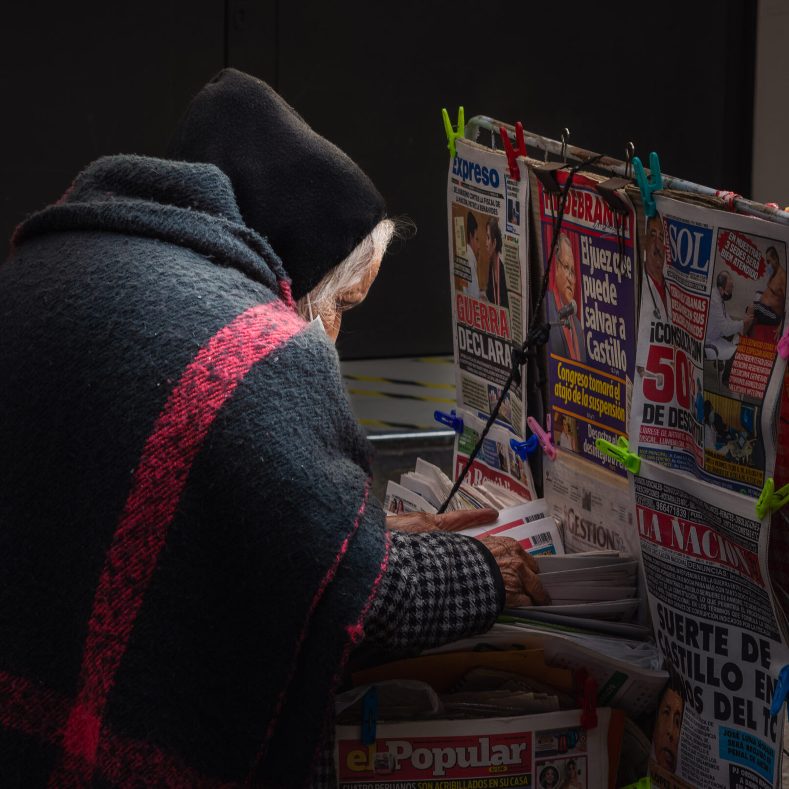 Old Peruvian street woman with newspapers