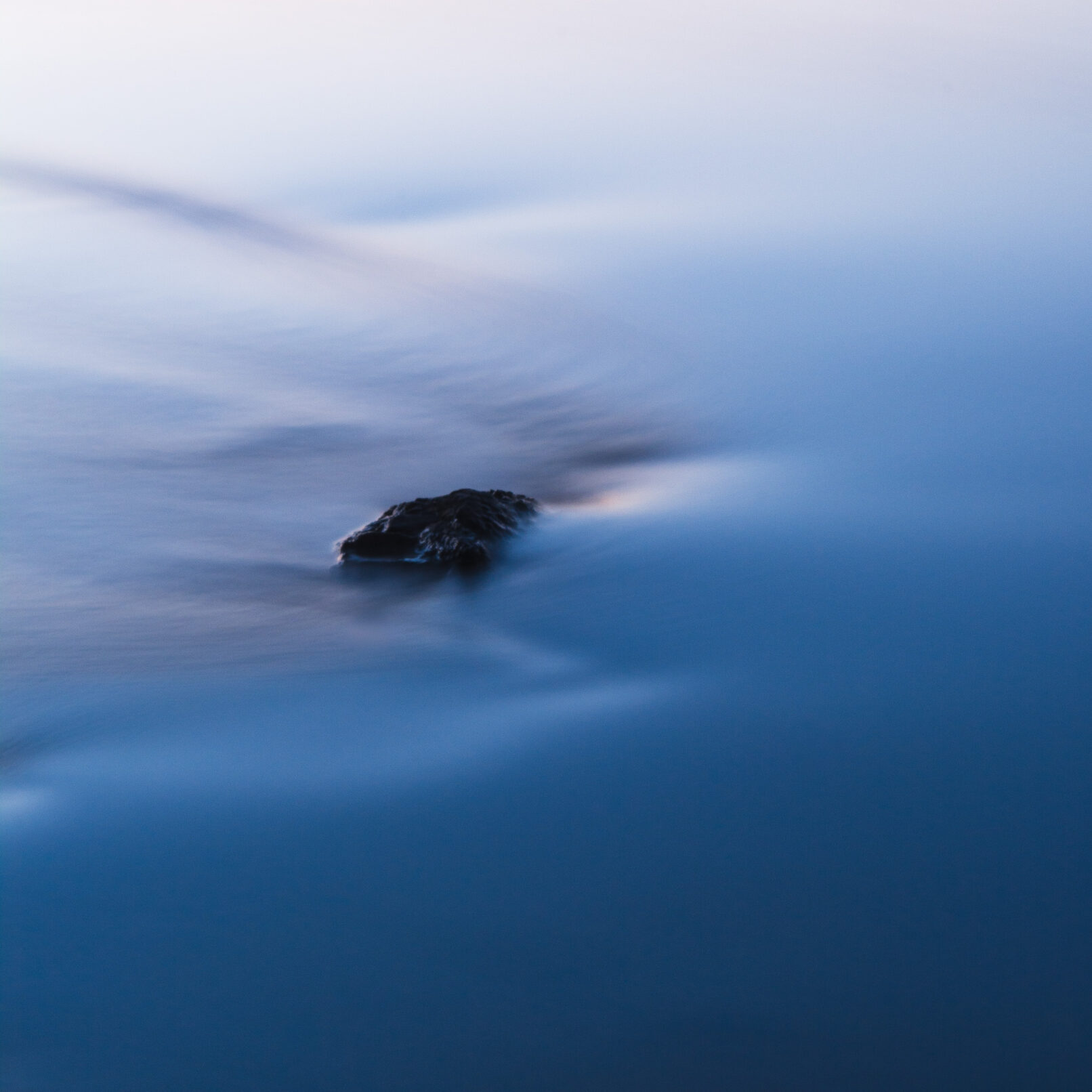 Rock in blue water